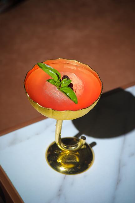 A red cocktail in a gold coupe