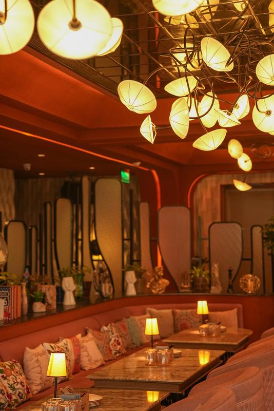 The indoor lounge with lantern lights and banquettes
