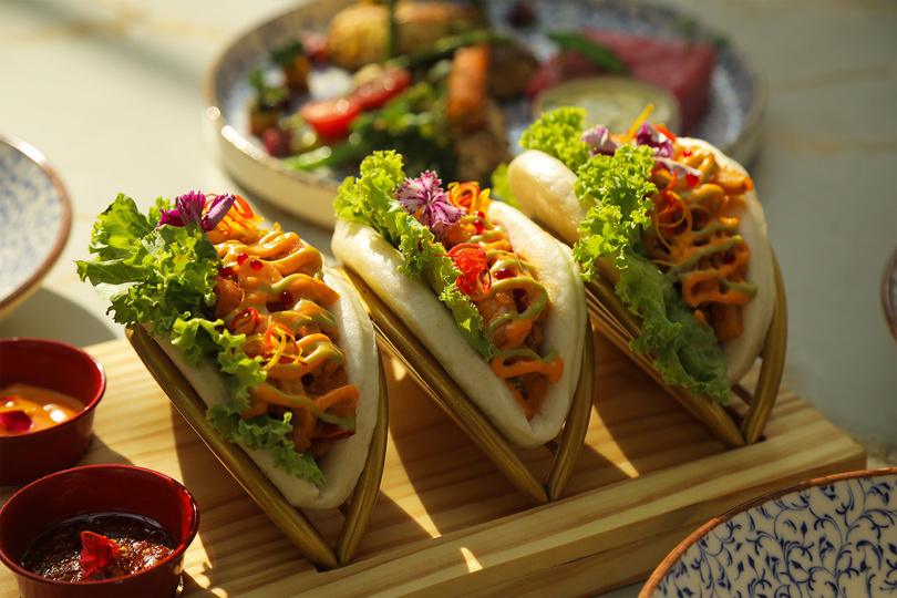 Bao tacos served on a wooden stand